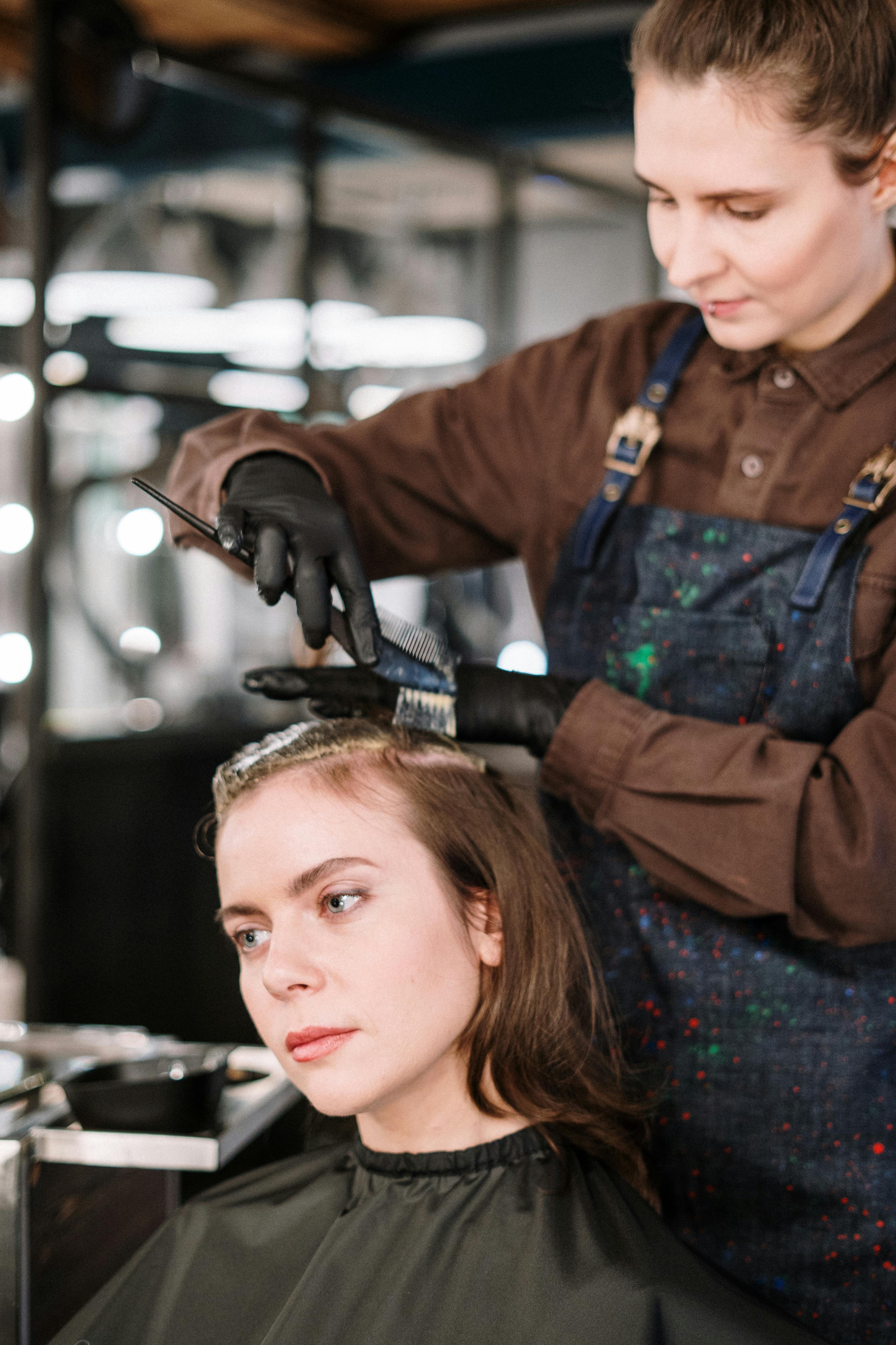 Professional stylist applying custom hair color with precision brush technique