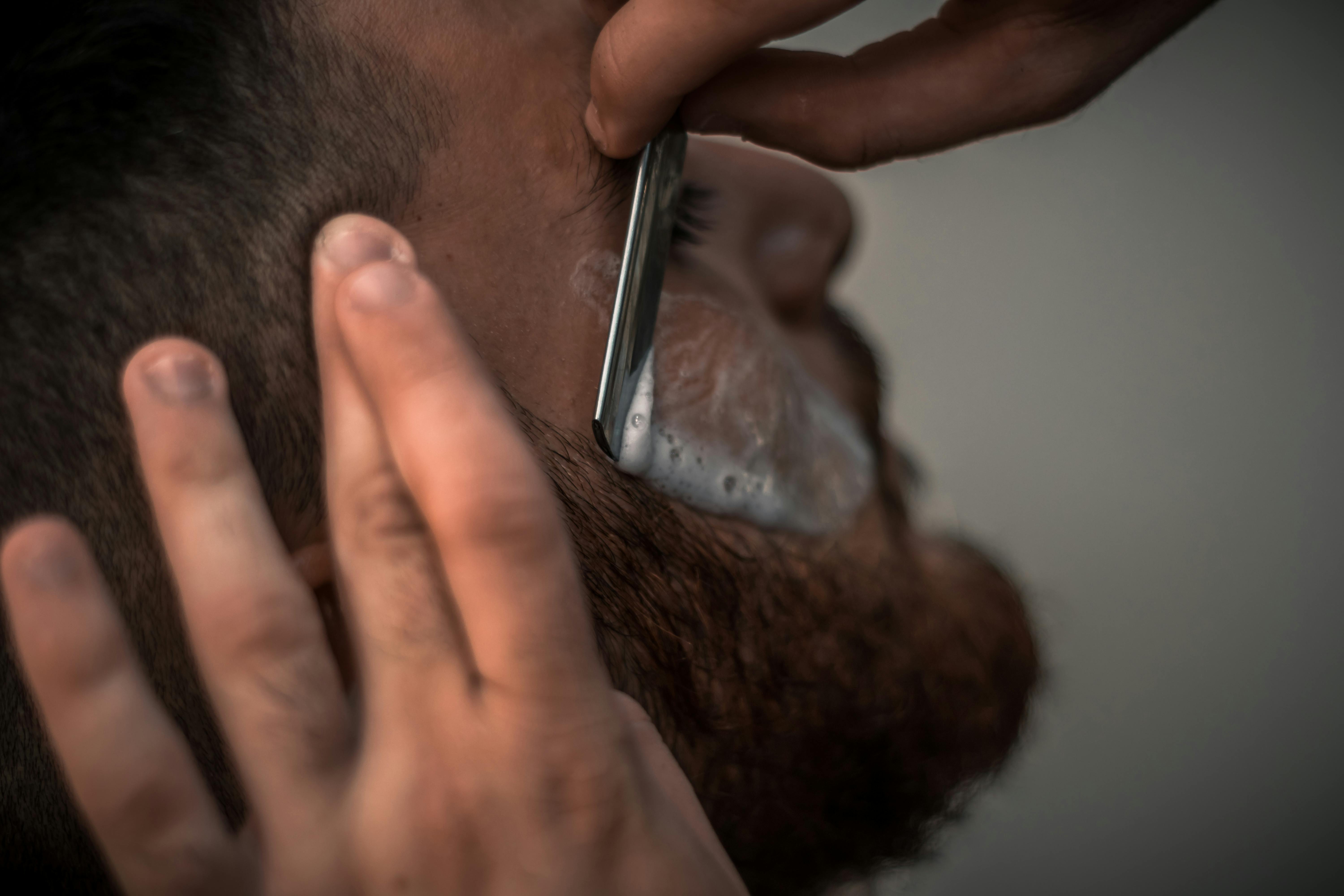 Close-up of a traditional straight razor shave with lather at Sharp Cuts Barbershop